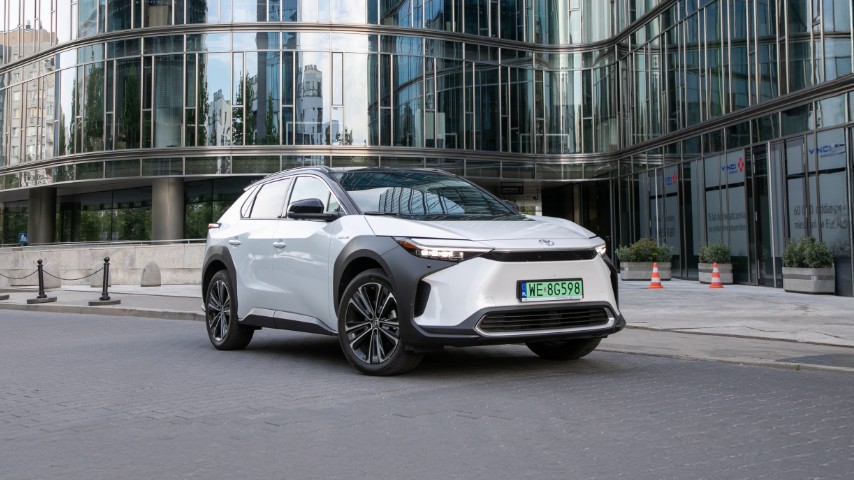 Toyota bZ4X zaparkowana na tle szklanego budynku